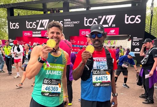 James Cooper holding his marathon medal at the race finish