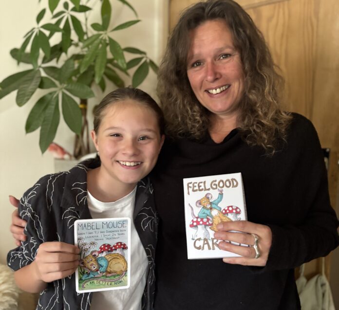 Nicky and Mabel Mouse hold the Feel Good cards