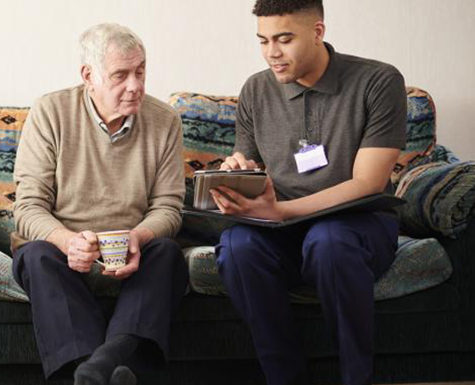 Elderly man is guided through a care assessment by a health worker