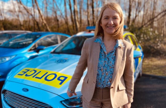 Sussex PCC Katy Bourne standing in front of a patrol car