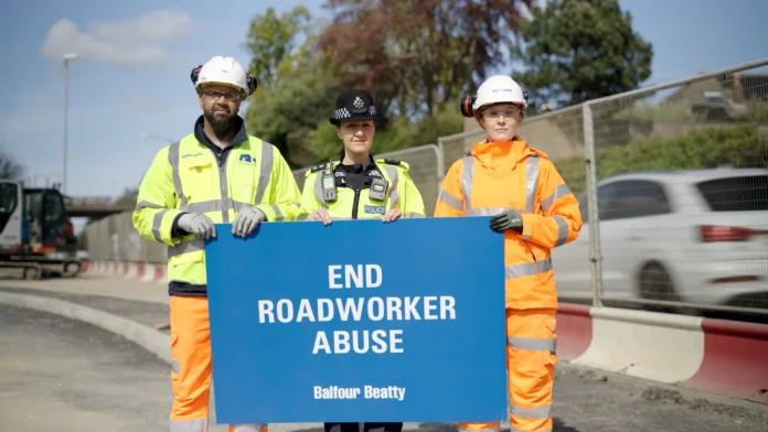 Highways workers hold sign saying 